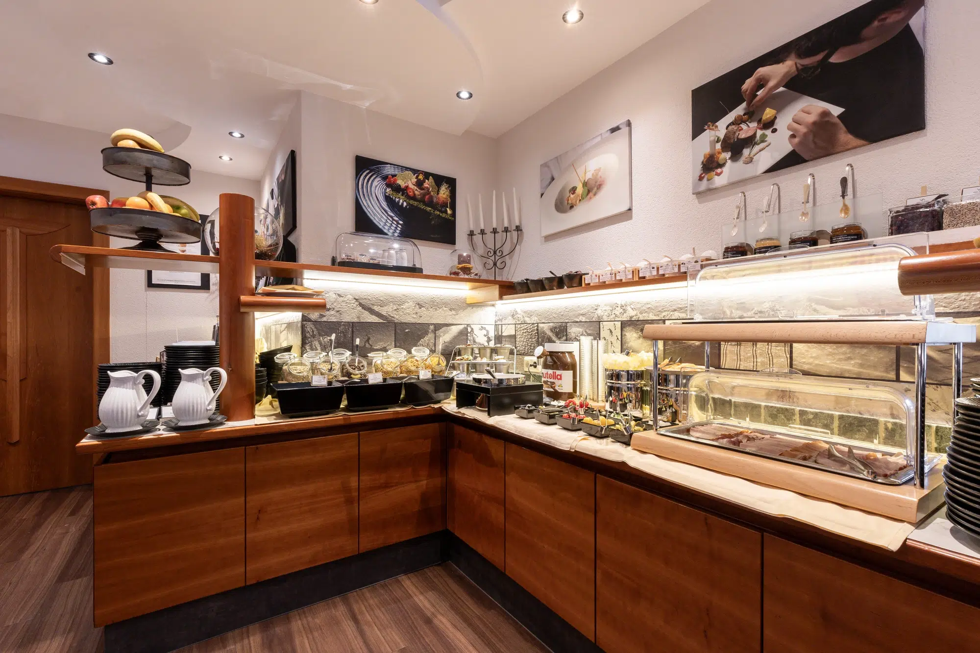 Buffet counter with various dishes, drinks, and utensils in a well-lit restaurant atmosphere.