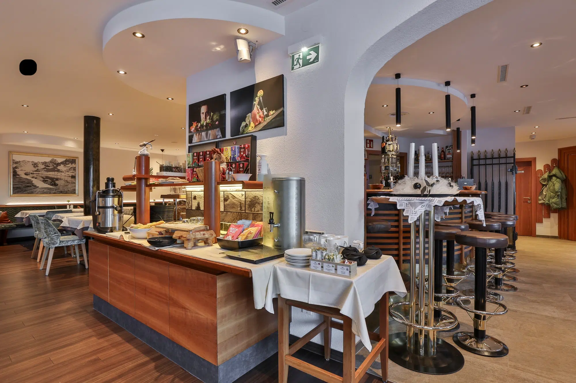 Buffet table with breakfast items in a modern restaurant with bar stools and vibrant art.